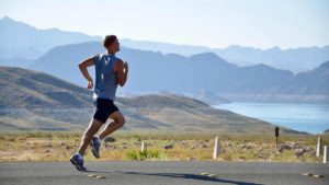 Man Jogs along the coast, Ocean in the background.